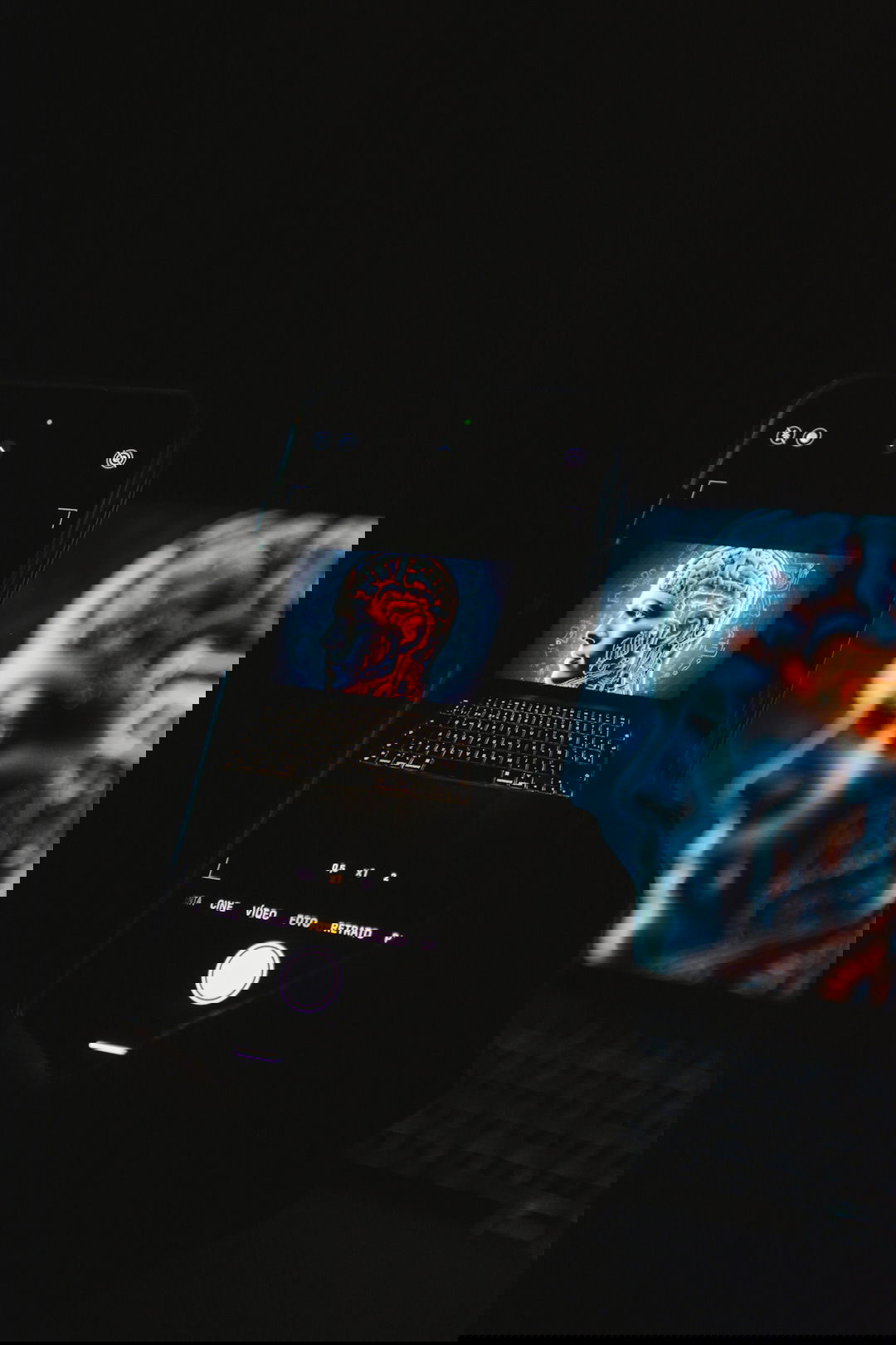 a cell phone sitting on top of a laptop computer